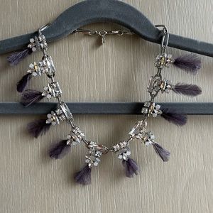 Embellished necklace with purple feathers.